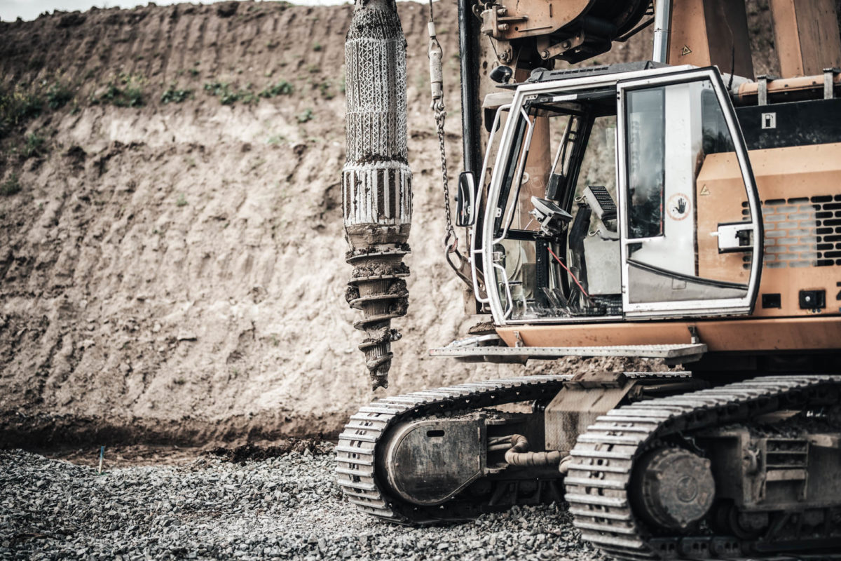 Construction site, highway building with industrial rotary drilling machinery close up